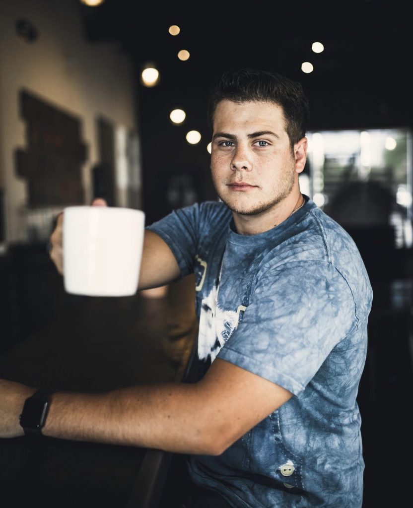 person holding a cup of drip coffee