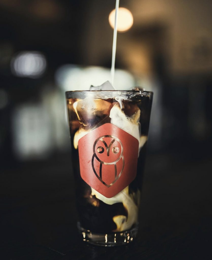 pouring milk over iced coffee