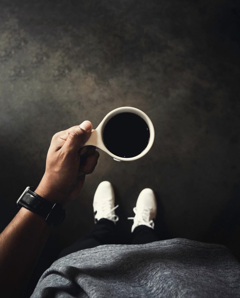 person holding a cup of drip coffee